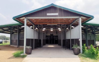 The added entryway of a round horse walker