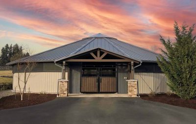 A fully enclosed, round horse walker at sunset