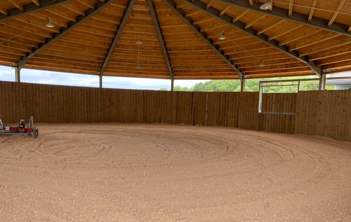 A covered round pen with nicely groomed footing