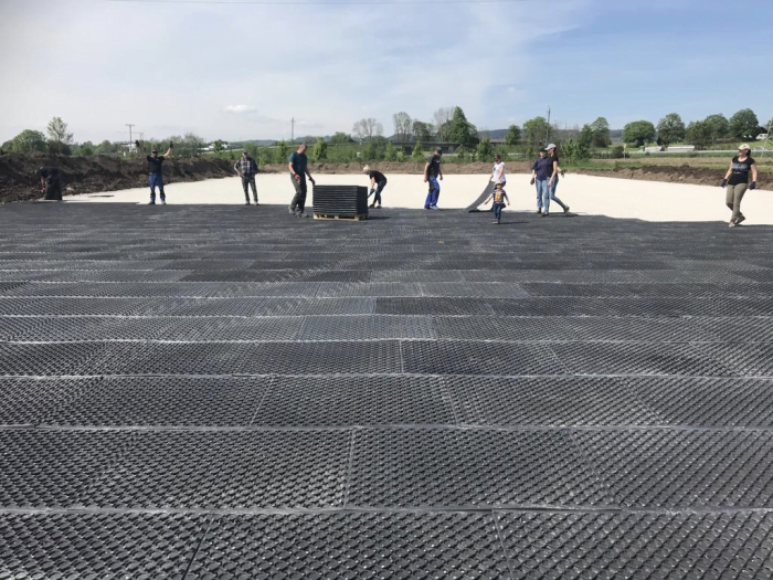 Arena base mats being installed in an outdoor arena