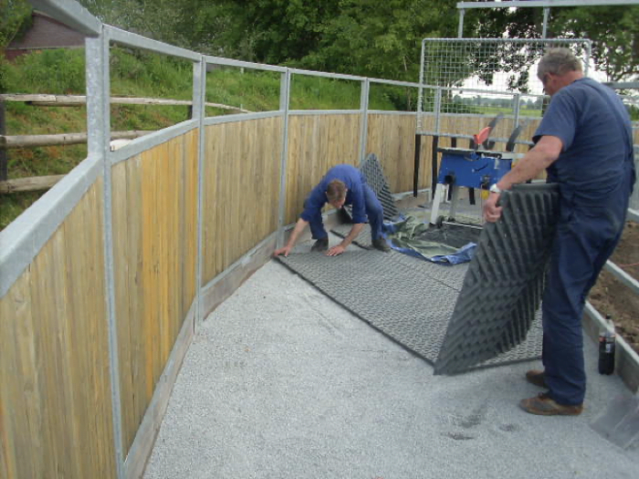 Arena mats being installed in a round pen