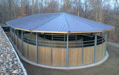 An oval horse walker with a cover, taken from the short side and slightly above