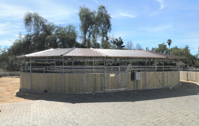 An oval horse walker with a cover taken on a sunny day