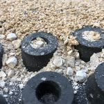 An arena mat close up that is partially covered in sand