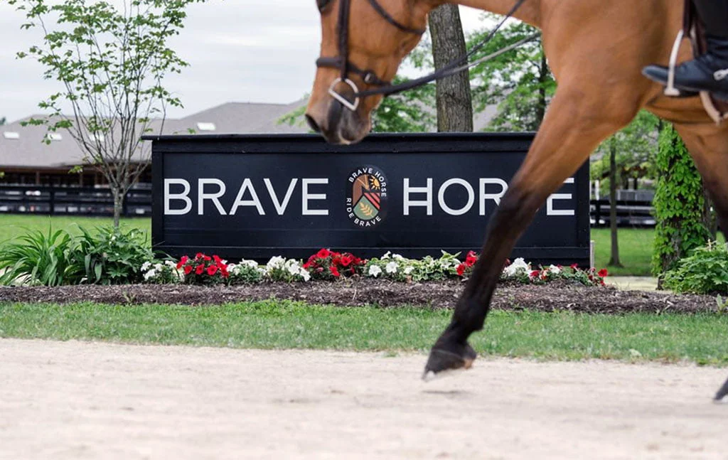 A horse trots by the Brave Horse sign in the new outdoor arena.