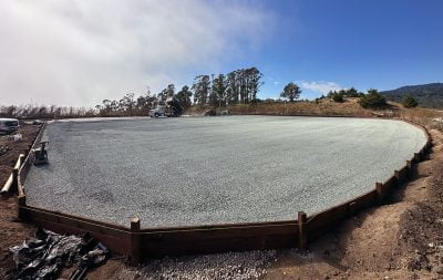 A wide angle shot of the outdoor arena at Half Moon Bay under construction, with HIT DrainGrids installed and sand in the beginning stages of being laid.