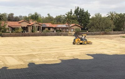 A piece of heavy machinery spreads and events out sand in the new arena in Rancho Santa Fe.