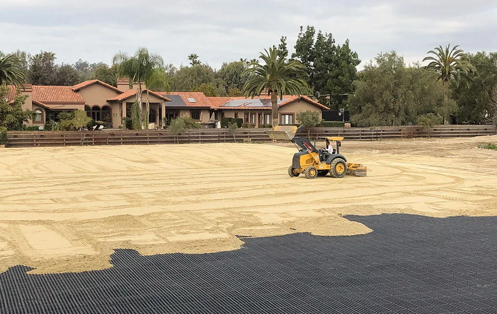 A piece of heavy machinery spreads and events out sand in the new arena in Rancho Santa Fe.
