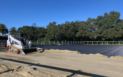 Construction equipment evenly spreads and flattens sand in a new outdoor arena that's being built at Hope Ranch.
