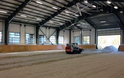 Heavy equipment adds and levels sand at the indoor arena in Langley, BC.
