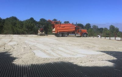 A construction truck dumps sand as the new outdoor dressage arena at palos verdes is being built.