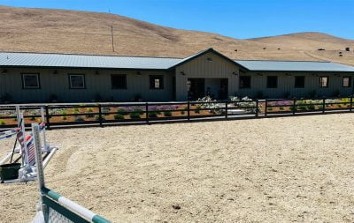 The completed outdoor jumping arena at Sage Hill Farm, with the barn in the background,