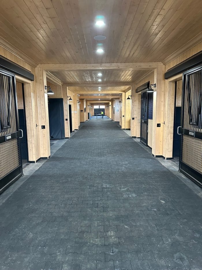 Rubber pavers laid out in a barn aisle.