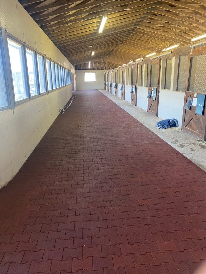 Terra Cotta colored rubber pavers installed in a barn aisle